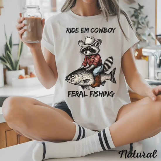 Hilarious Cowboy Raccoon Riding Fish T-Shirt | Western Humor Country Animal Tee